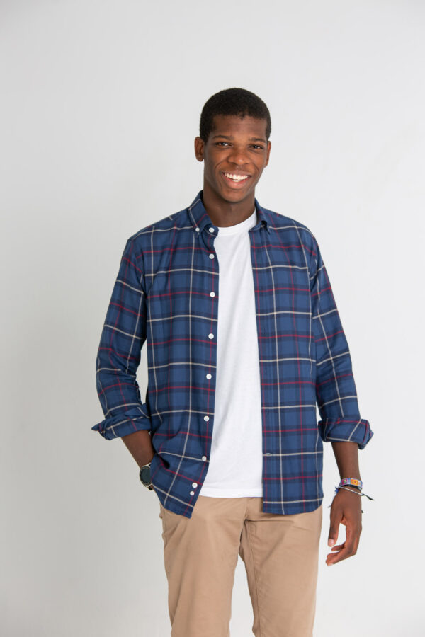 Modelo joven con camisa de cuadros de color azul, rojo y blanco